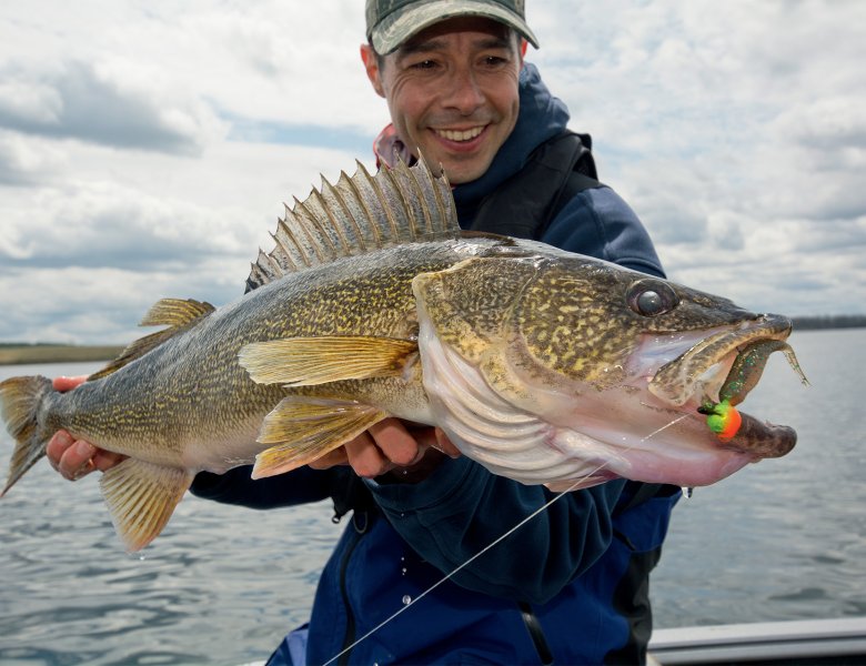 Jeune homme qui tient un gros poisson