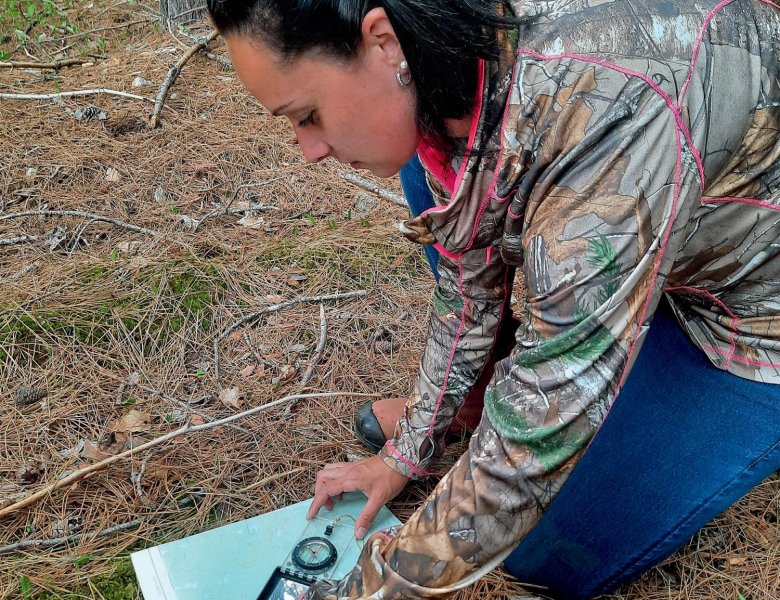 Une femme qui utilise un Azimut sur une carte